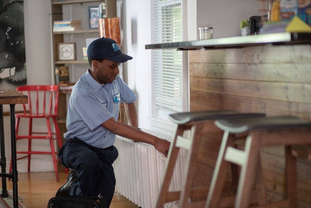 HVAC technician in home with blue hat